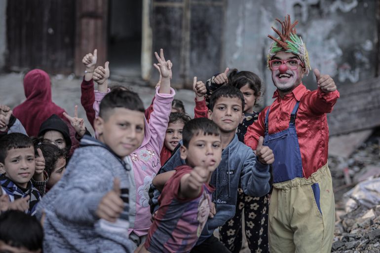 بالصور.. مهرّج مکلوم یرسم الابتسامه على وجوه أطفال غزه